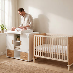 Papa changeant son bébé sur la table à langer à côté du lit