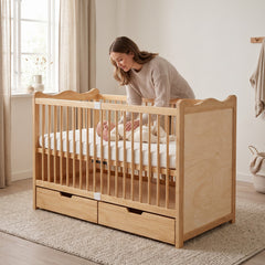 Maman couchant son bébé dans le lit bébé en bois